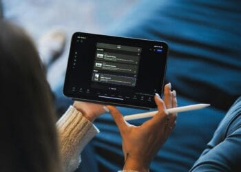 Person holding a tablet and stylus device.